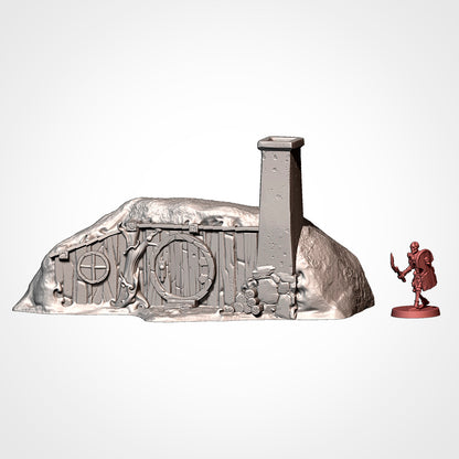 Burrow 1: front view beside a 32mm figure, square stone chimney, log pile and round window (Txarli Factory render).