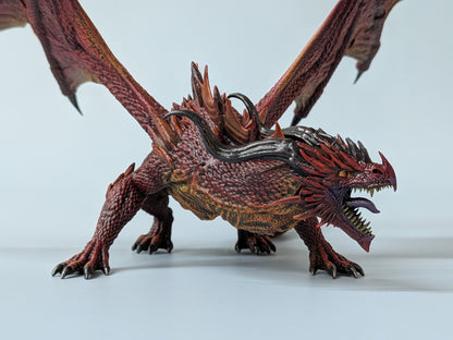 Painted ancient red dragon miniature with battle-torn wings